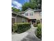 Charming two-story townhome with a walkway leading to the red front door and lush green bushes lining the path at 665 Oak Harbour Dr # 115, Altamonte Springs, FL 32701