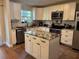 Well-equipped kitchen featuring white cabinets, granite countertops, stainless steel appliances, and an island at 665 Oak Harbour Dr # 115, Altamonte Springs, FL 32701