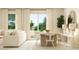 Sunlit living room merging into dining area with a natural wood table and backyard patio access at 2607 Skyline Loop, Kissimmee, FL 34758