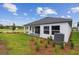 Backyard featuring a covered patio, lush grass, professional landscaping, and a picturesque view of a pond at 5950 Bristle Oak St, Mount Dora, FL 32757