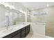 Bathroom with dual sinks and a glass-enclosed shower at 5950 Bristle Oak St, Mount Dora, FL 32757