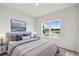 Bedroom with blue and gray bedding, a large window, and a framed picture above the bed at 5950 Bristle Oak St, Mount Dora, FL 32757