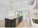 Modern kitchen with white cabinets, stainless steel appliances, a central island, and open floor plan at 5950 Bristle Oak St, Mount Dora, FL 32757
