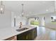 Bright, open kitchen with a large island, sink, and view into living area and outdoor space at 5950 Bristle Oak St, Mount Dora, FL 32757