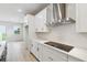 Well-lit kitchen featuring white cabinets, stainless steel appliances, and light hardwood floors at 5950 Bristle Oak St, Mount Dora, FL 32757