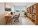 Home office with built-in bookshelves, desk, and two large windows at 5950 Bristle Oak St, Mount Dora, FL 32757