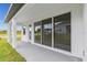 A covered outdoor patio features sliding glass doors with screens and an extended concrete slab at 5950 Bristle Oak St, Mount Dora, FL 32757