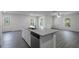 Kitchen island featuring a stainless steel dishwasher, sink, and granite countertop, plus gray wood-look floors at 596 Bay Leaf Dr, Poinciana, FL 34759