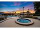 Community pool with a spa, sun loungers, and a covered pavilion set against a vibrant sunset sky at 6214 Sw 96Th Pl, Ocala, FL 34476