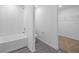 Bathroom featuring white tiled walls, shower-tub combo, and view to walk-in closet at 639 Gila Dr, Poinciana, FL 34759
