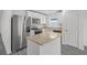 Modern kitchen featuring stainless steel appliances, white cabinetry, and a granite countertop island at 639 Gila Dr, Poinciana, FL 34759