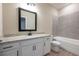 Bathroom features a white vanity with granite countertop, bathtub, and wood floor at 7696 Somersworth Dr, Kissimmee, FL 34747