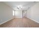 A spacious living room featuring light gray walls, wood floors, and a ceiling fan at 7696 Somersworth Dr, Kissimmee, FL 34747
