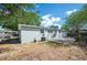 A home's rear exterior featuring a concrete patio, grassy area, new paint, windows, and cooling unit at 1037 Waynesville Ave, Lakeland, FL 33801