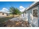 View of a home's backyard featuring a concrete patio, partial fence, and a mature shade tree at 1037 Waynesville Ave, Lakeland, FL 33801