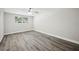Bedroom with wood-look floors, a ceiling fan, and natural light from a window at 1037 Waynesville Ave, Lakeland, FL 33801