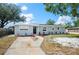 A lovely single-story home features manicured lawn and landscaping leading to the front door at 1037 Waynesville Ave, Lakeland, FL 33801