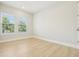 Well-lit bedroom with windows and neutral walls, featuring wood-look flooring at 214 E Harding St, Orlando, FL 32806