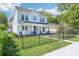 Inviting two-story home showcasing manicured lawn, black wrought iron fence, and beautiful landscaping at 214 E Harding St, Orlando, FL 32806