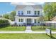 Charming two-story home featuring black wrought iron fence, inviting front porch, and manicured lawn at 214 E Harding St, Orlando, FL 32806