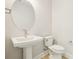 Well-lit half bathroom featuring a pedestal sink and modern toilet at 214 E Harding St, Orlando, FL 32806