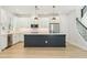 Spacious kitchen featuring white cabinets, a dark island with quartz countertops, and stainless steel appliances at 214 E Harding St, Orlando, FL 32806