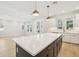 Bright kitchen with large island, white cabinets, modern appliances, and wood floors throughout at 214 E Harding St, Orlando, FL 32806