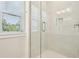 Luxury shower with glass doors and white marble tile and fixtures at 214 E Harding St, Orlando, FL 32806