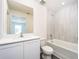 Bright bathroom featuring a white vanity with modern fixtures, a tub, and decorative light-colored wall tiles at 3817 Corsican Pl, Lake Alfred, FL 33850