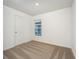 Empty bedroom showing neutral walls, tan carpet, bright window and a white door at 3817 Corsican Pl, Lake Alfred, FL 33850