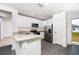 Bright kitchen with stainless steel appliances, granite countertops, and gray wood flooring at 3817 Corsican Pl, Lake Alfred, FL 33850