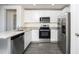 Bright kitchen with stainless steel appliances, granite countertops, and gray wood flooring at 3817 Corsican Pl, Lake Alfred, FL 33850