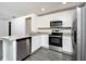 Bright kitchen with stainless steel appliances, granite countertops, and gray wood flooring at 3817 Corsican Pl, Lake Alfred, FL 33850