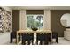 Dining room featuring contemporary decor, a wooden table, and large windows showcasing the outdoor view at 4670 Yellow Elder Way, Kissimmee, FL 34758