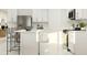 Bright, modern kitchen features white cabinetry, an island with bar seating, and stainless steel appliances at 4670 Yellow Elder Way, Kissimmee, FL 34758
