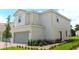 Exterior of a two-story home featuring a two-car garage, well-maintained lawn and landscaping at 616 Bay Leaf Dr, Poinciana, FL 34759
