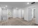 Hallway with neutral carpet, white walls, and multiple doorways, offering a bright and spacious feel to the upper level at 616 Bay Leaf Dr, Poinciana, FL 34759
