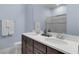 Bathroom featuring double sinks, dark wood cabinets, white countertop and a glass door shower at 7071 Spring Park Dr, Winter Garden, FL 34787