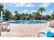 Community pool with lounge chairs and patio furniture set in lush landscaping at 7071 Spring Park Dr, Winter Garden, FL 34787