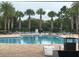 Beautiful community pool with palm trees, lounge chairs, and inviting atmosphere at 7071 Spring Park Dr, Winter Garden, FL 34787