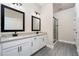 Modern bathroom featuring double sink vanity with granite counters and a tiled glass shower at 7740 Somersworth Dr, Kissimmee, FL 34747