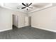 Bright and airy main bedroom featuring tray ceiling, ceiling fan, and en suite bathroom at 7740 Somersworth Dr, Kissimmee, FL 34747
