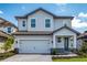 Charming two-story home featuring a two-car garage, stone accents, and a well-manicured front yard at 7869 Somersworth Dr, Kissimmee, FL 34747