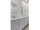 A modern bathroom featuring double sinks with white cabinets and a vanity at 385 Begonia Ct, Poinciana, FL 34759