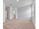 A spacious bedroom with carpet flooring, natural light, and a door leading to the bathroom at 385 Begonia Ct, Poinciana, FL 34759