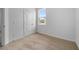 Bright bedroom with neutral carpet, white walls, and a window providing natural light at 385 Begonia Ct, Poinciana, FL 34759