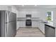 Well-equipped kitchen with stainless steel appliances, white cabinets, and granite countertops at 385 Begonia Ct, Poinciana, FL 34759