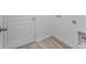 A well-lit laundry room showcasing neutral paint, vinyl wood floors, and white trim at 385 Begonia Ct, Poinciana, FL 34759