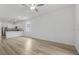 Bright living room featuring hardwood floors, a ceiling fan, and kitchen with stainless steel appliances at 385 Begonia Ct, Poinciana, FL 34759
