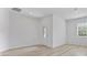 A brightly lit living room with wood-look floors, a front door, and a window at 385 Begonia Ct, Poinciana, FL 34759